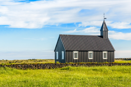 Budakirkja black painted lutheran church erected in 1847 with blue sky and clouds in the background, Snaefellsnes Peninsula, West Icelandの写真素材