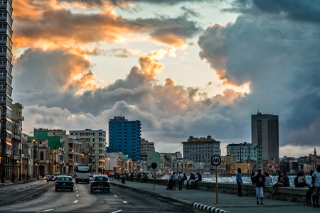 Malecon promenade street with walking people and road with traffic in the evening time with sunset clouds, Havana, Cubaのeditorial素材