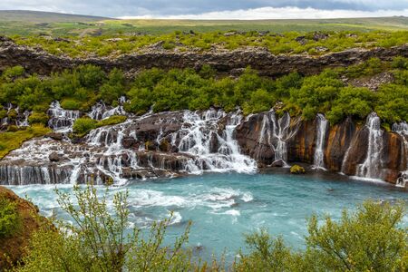 Hraunfossar waterfall powerful streams falling into Hvita river turquoise waters, Husafell, Western Icelandの写真素材