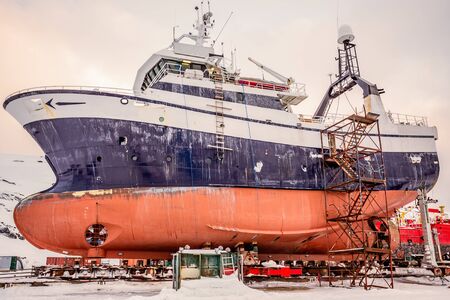 Fishing ships hulls in dockyard on maintenance during the winter time, port of Nuuk, Greenlandの写真素材