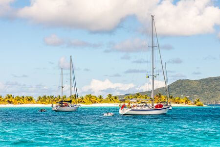 Turquoise sea and anchored yachts at Sandy beach island, near Carriacou island, Grenada, Caribbean...
