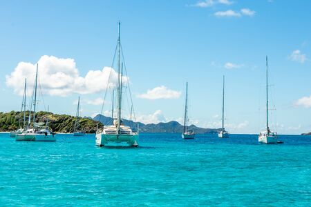Turquoise colored sea with ancored yachts and catamarans, Tobago Cays tropical islands, Saint...