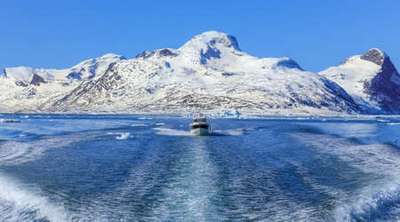 Motor boat in the middle of Nuuk fjord with frozen rocks in the background, Greenlandの写真素材