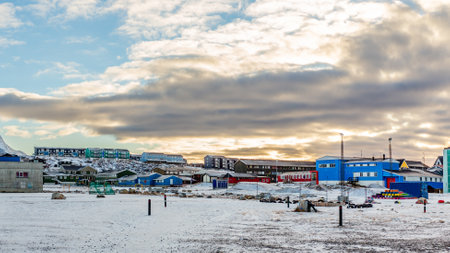 Inuit houses on the hill in Nuuk city covered in snow in a sunset lights, Greenland