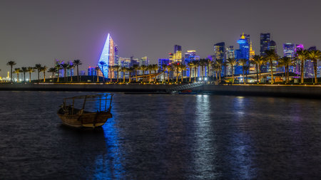 Doha city business downtown center panorama illuminated at night, with modern skyscrapers, promenade...