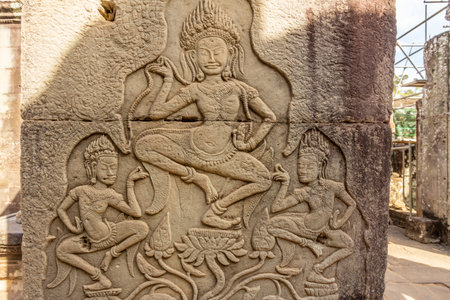 Ancient Bayon ruined temple walls decorated with dancing apsaras statues, Angkor Archaeological...