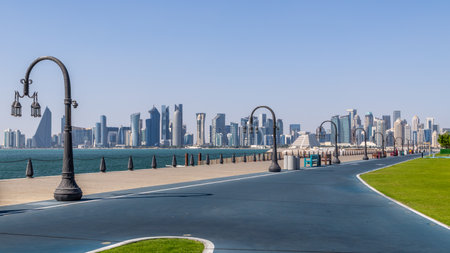 Doha modern business downtown center skyscrapers shoreline with corniche and street lights at the sea bay, Qatarの写真素材