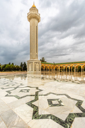Minaret tower of mausoleum of Habib Bourguiba on a cloudy day with decorated marble courtyard, Monastir, Tunisiaの写真素材