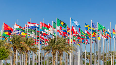Many worlds countries national flags waving on the wind, with UN, EU, GCC banners with palms in the foreground, Doha, Qatarの写真素材