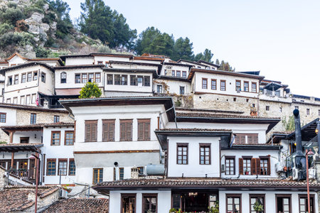 Albanian town historic center with traditional Ottoman houses on a hillside with white stone...