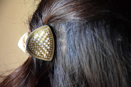 Close view of fancy pearl clip in beautiful long reddish brown hairの写真素材