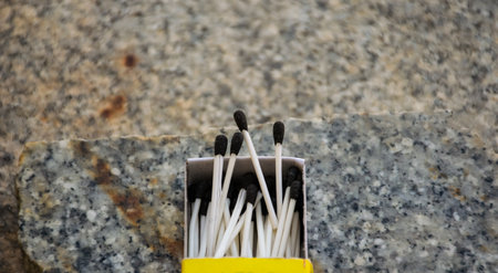 Close up of open single cardboard match box on granite stone background,Box filled with tiny match...