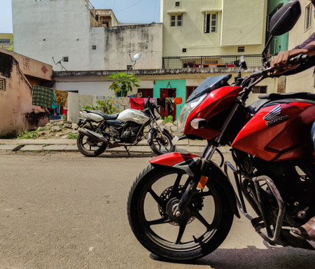 Bangalore , Karnataka , India- December 15th 2020; Side view of red color motorbike or motorcycle man riding on asphalt road in bangalore city India.のeditorial素材