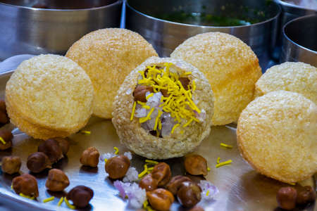 Stock photo of traditional popular Indian street food or snacks Panipuri. stuffed puri with onion black chickpeas and yellow shev ready to eat or ready to served with spicy , sweet and sour chutney.の写真素材