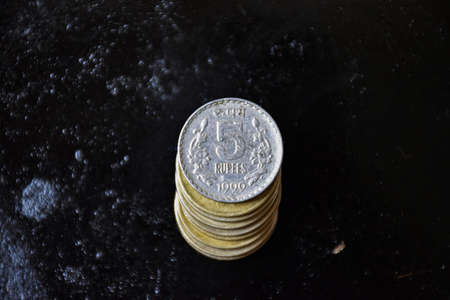 stock photo of Indian five rupees coins kept in one over other on black color background at Bangalore, Karnataka, India. selective focus.の写真素材