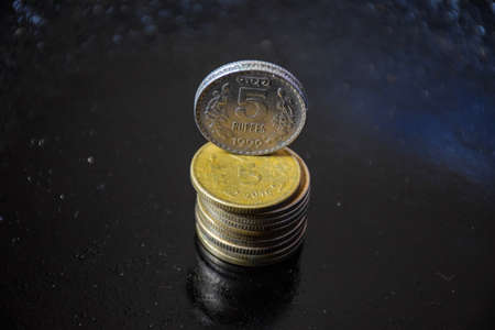 stock photo of Indian five rupees coins kept in one over other on black color background at...