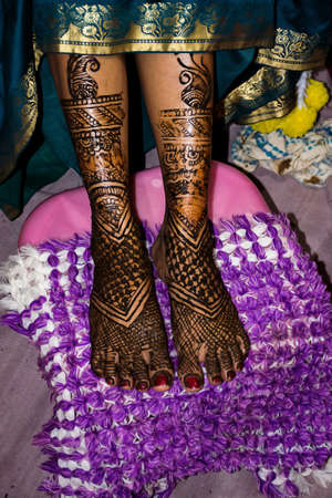 Stock photo of beautiful Indian bridal showing her henna legs, applied on the occasion of wedding at Kolhapur, Maharashtra, India. Henna symbolizes positive spirit and good luck for bride and groom.の写真素材