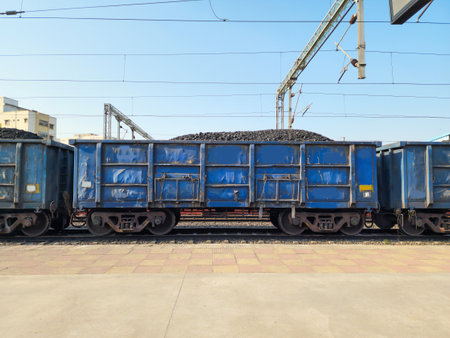 Stock photo of blue color painted open goods wagon loaded with charcoal transported to power, metal, Chemical production.Picture captured under bright sunlight at Hyderabad, Telangana, India.の写真素材