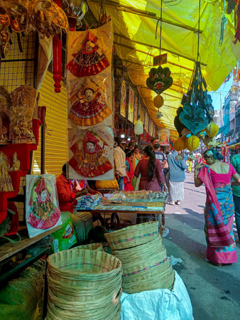 Tuljapur, India- October 28th 2022; stock photo of books,goddess face mural, cloths,cotton garland, cane basket items used for worshiping god, kept in a shop for sale people buying items from vendor.のeditorial素材