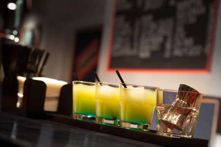 three glasses of cocktails are on the barの写真素材