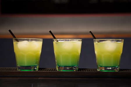 three glasses of cocktails are on the barの写真素材