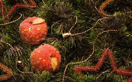 Christmas ornaments in the form of apples on green tinselの写真素材