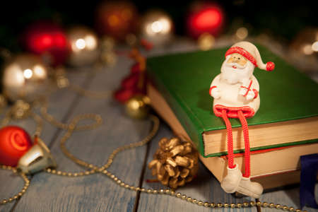Christmas toy Santa Claus sits on booksの写真素材