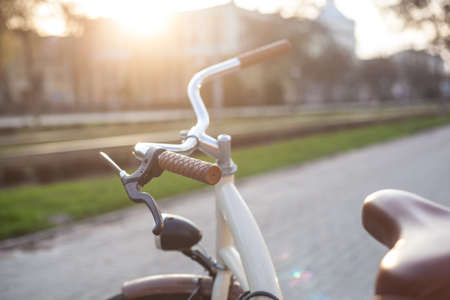 Bicycle of beige color with a lantern on the alley in the city in the springの写真素材