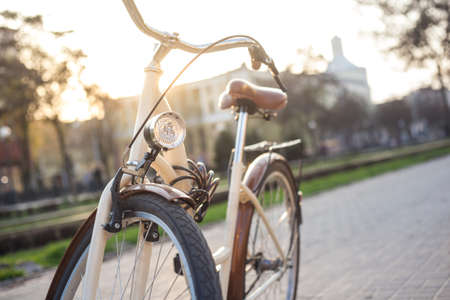 Bicycle of beige color with a lantern on the alley in the city in the springの写真素材