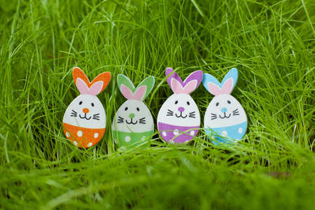 Easter egg little rabbit figurine on green grass