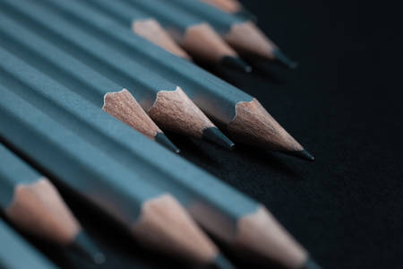 Gray sharpened pencils isolated on black background.の写真素材