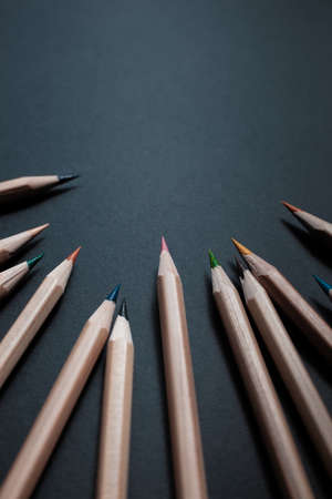 Sharpened pencils of different colors made of light wood isolated on black background.の写真素材