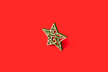 Decorative Christmas star made of wood with green patterns isolated on red backgroundの写真素材