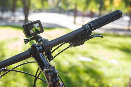 Action camera with the included screen mounted on the handlebar of a bicycle in the parkの写真素材