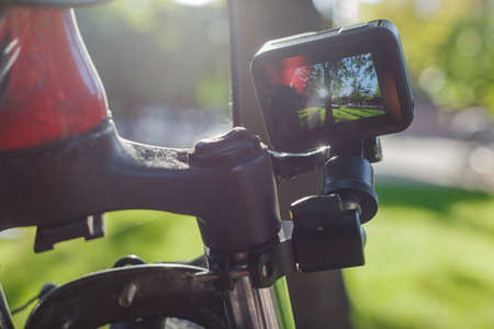Action camera with a screen on, mounted next to a mountain bike wheelの写真素材