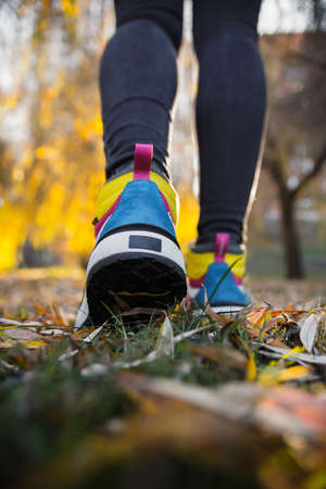 Sports multi-colored high boots on female legs in black jeans on the background of the cityの写真素材