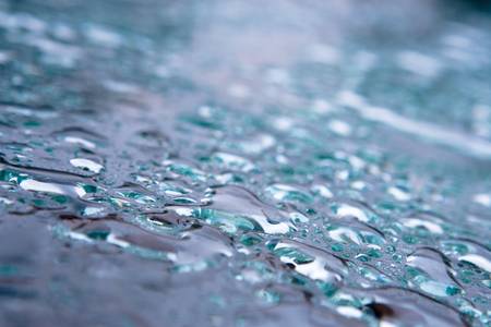 Rain drops on blue tinted glass table.の写真素材