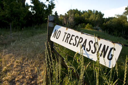 No Trespassing sign posted on barb wire fence