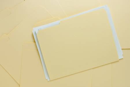 File Folder with Paper on Messy Pileの写真素材