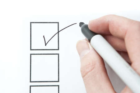 Hand Writing Check Mark. Focus on check mark shape on paper surface.の写真素材