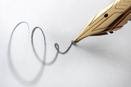 Extreme close up of fountain pen and signature. Selective focus with critical sharpness on tip of pen nib.の写真素材