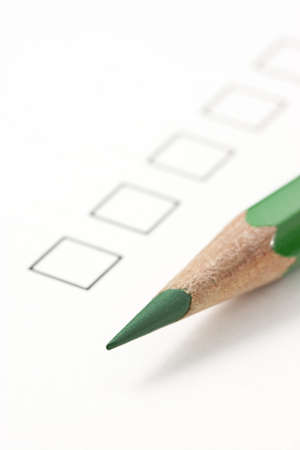 Check box on survey with green pencil. Focus on tip of pencil