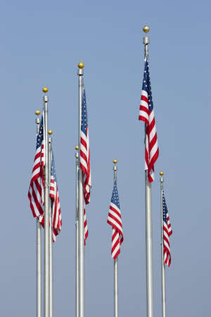 American Flags against blue sky in vertical orientation. Focus on middle front flag.の写真素材