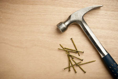 Hammer and nails on wood plank with copy space area at leftの写真素材