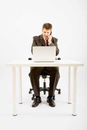 Young businessman working with phone and laptop computerの写真素材