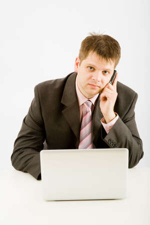 Young businessman working with phone and laptop computerの写真素材