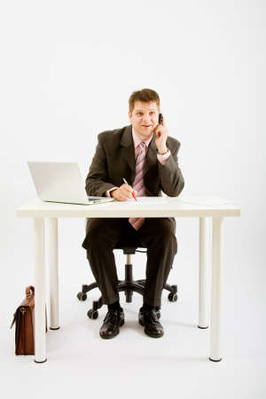 Young businessman working with phone and laptop computerの写真素材