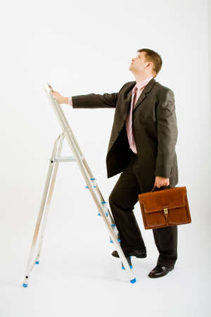 Business man with ladder on a white backgroundの写真素材