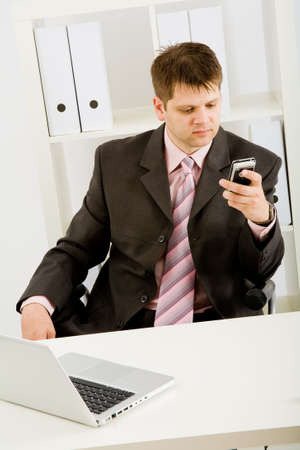 Young businessman working with phone and laptop computerの写真素材