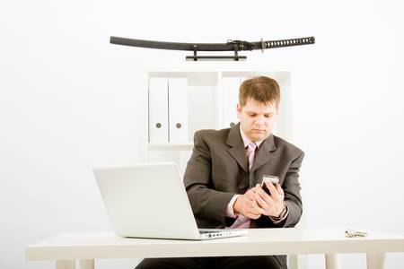 Young businessman working with phone and laptop computerの写真素材